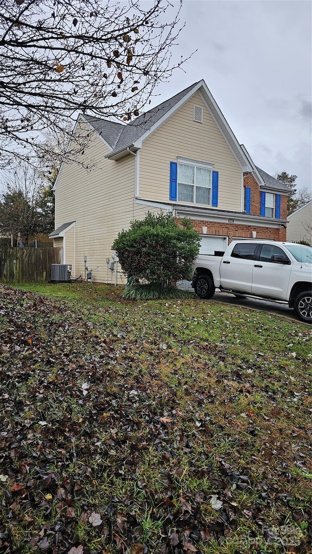 view of side of home featuring central air condition unit and a garage