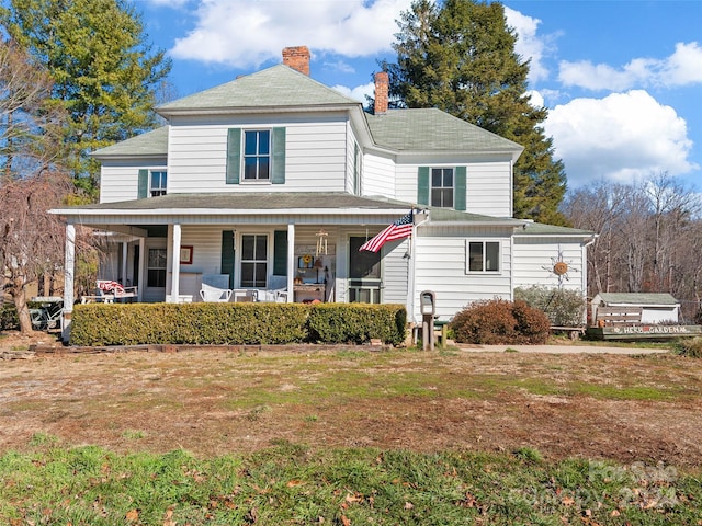 farmhouse inspired home featuring covered porch and a front lawn