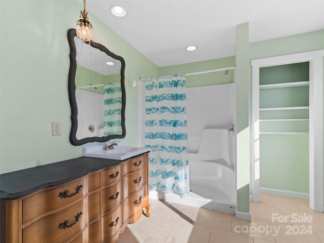 bathroom featuring tile patterned floors, vanity, and curtained shower