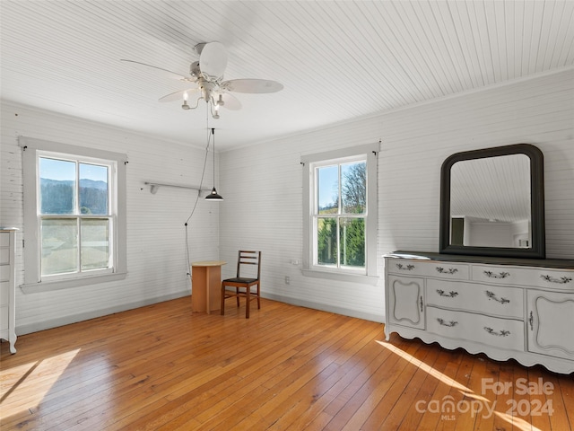 unfurnished room featuring ceiling fan, light hardwood / wood-style flooring, and brick wall