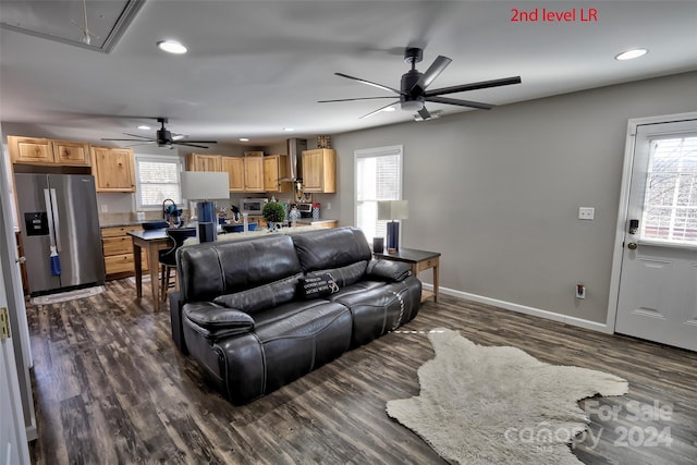 living room featuring dark hardwood / wood-style floors, ceiling fan, and sink