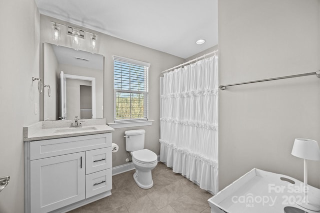 bathroom with tile patterned flooring, vanity, and toilet