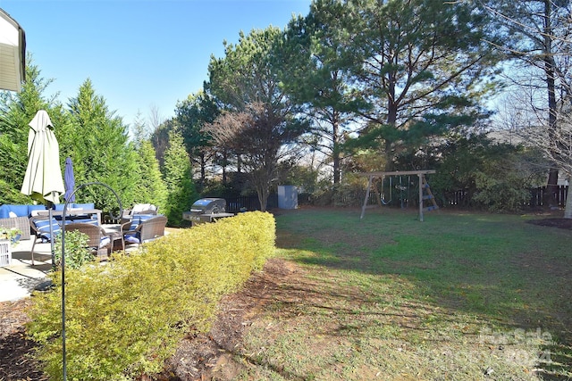 view of yard with an outdoor living space, a playground, and a storage unit