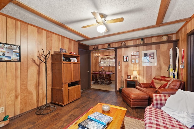 living room featuring ceiling fan, dark wood-type flooring, and a textured ceiling