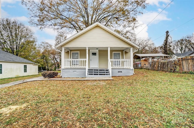 bungalow with covered porch and a front lawn