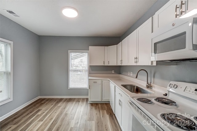 kitchen featuring white cabinets, light wood-type flooring, white appliances, and sink