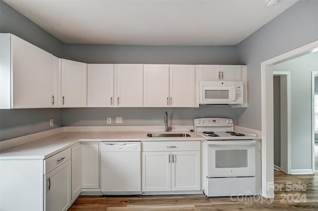 kitchen with sink, white cabinets, white appliances, and light hardwood / wood-style flooring