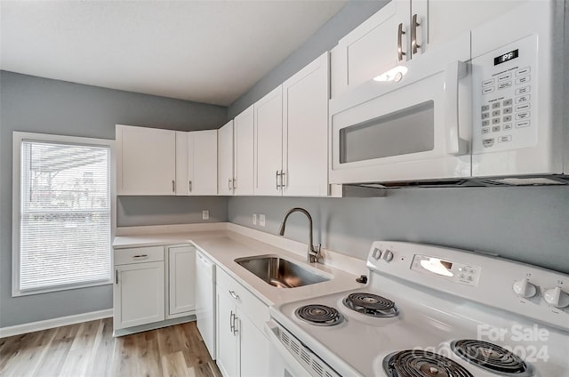 kitchen featuring white cabinetry, sink, light hardwood / wood-style floors, and white appliances