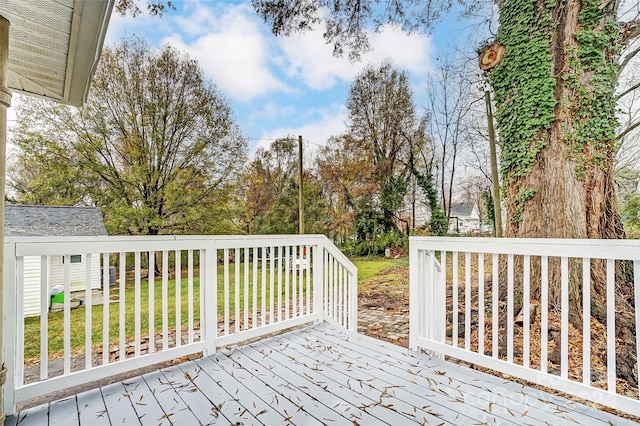 wooden deck featuring a lawn