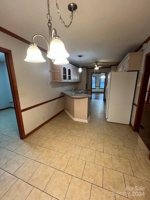 kitchen with kitchen peninsula, ceiling fan, crown molding, decorative light fixtures, and white fridge