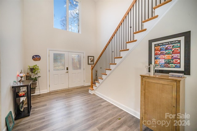 entrance foyer featuring a towering ceiling and hardwood / wood-style flooring