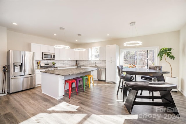 kitchen with pendant lighting, a center island, white cabinetry, and appliances with stainless steel finishes