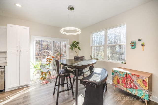 dining area with light wood-type flooring and plenty of natural light