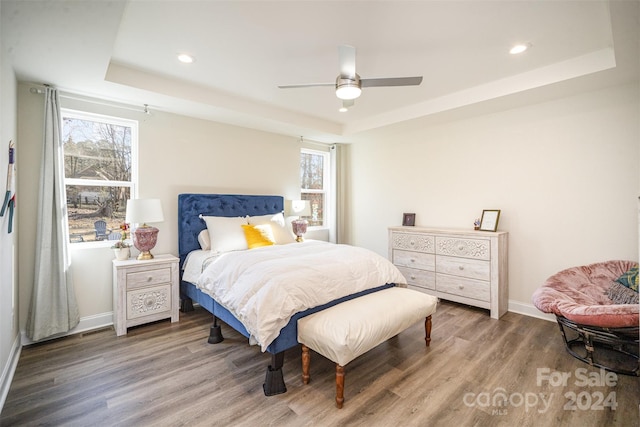 bedroom featuring a tray ceiling, ceiling fan, and hardwood / wood-style flooring