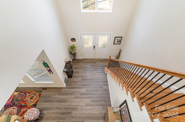 foyer featuring dark hardwood / wood-style floors, a high ceiling, and french doors