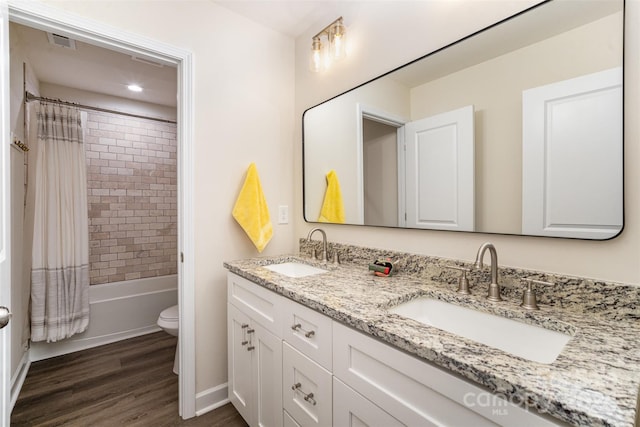 full bathroom featuring toilet, hardwood / wood-style floors, vanity, and shower / tub combo with curtain