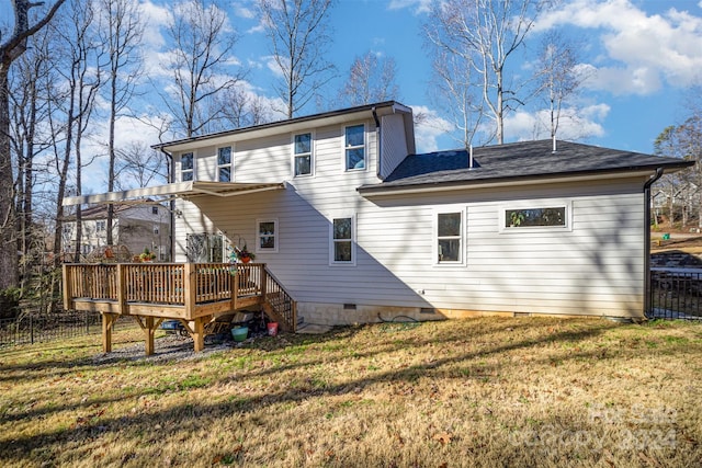 rear view of house featuring a lawn and a wooden deck