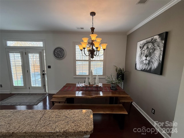 dining room with a wealth of natural light, an inviting chandelier, dark wood-type flooring, and ornamental molding