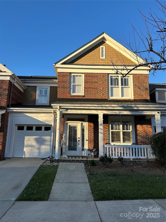 view of front of house with a porch, concrete driveway, and brick siding