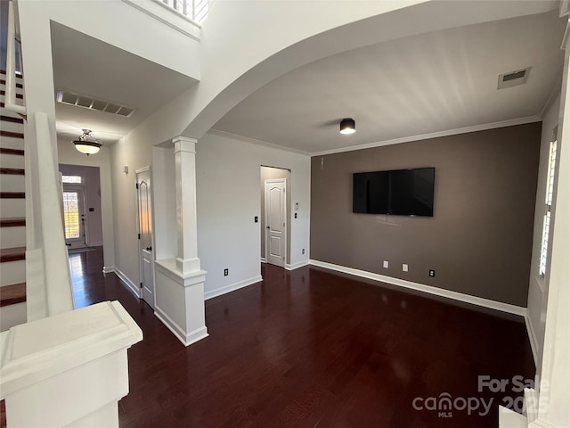 entrance foyer with arched walkways, visible vents, decorative columns, and wood finished floors