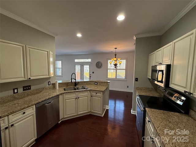 kitchen with ornamental molding, dark wood-style flooring, a peninsula, stainless steel appliances, and a sink