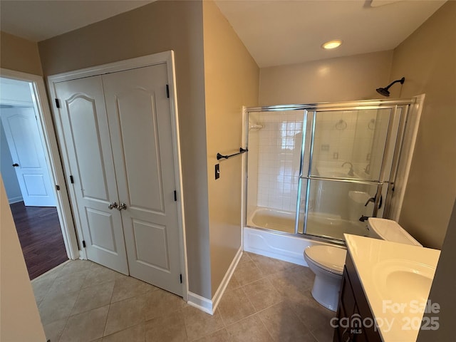 bathroom featuring toilet, shower / bath combination with glass door, vanity, and tile patterned floors