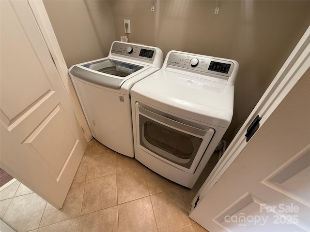 laundry area featuring washer and clothes dryer and light tile patterned flooring