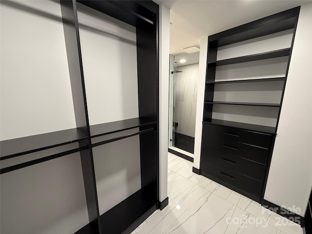 spacious closet featuring marble finish floor