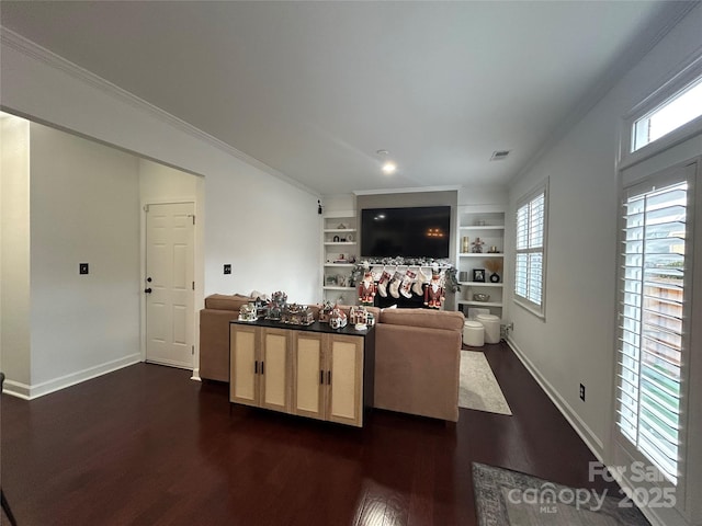 living room featuring built in features, dark wood-style flooring, crown molding, visible vents, and baseboards