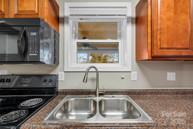 kitchen with dark stone counters, sink, and black appliances