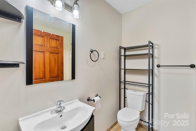 bathroom with tile patterned flooring, toilet, and sink