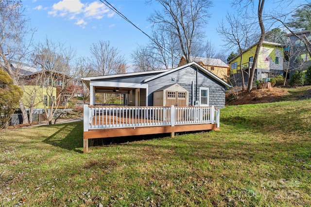 back of property with a lawn, ceiling fan, and a deck