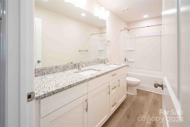 full bathroom with shower / bathing tub combination, toilet, vanity, and hardwood / wood-style flooring