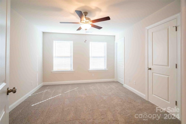 unfurnished room with light colored carpet and ceiling fan