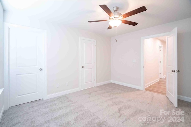 unfurnished bedroom with light colored carpet and ceiling fan