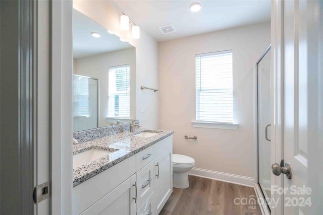 bathroom featuring vanity, toilet, wood-type flooring, and walk in shower