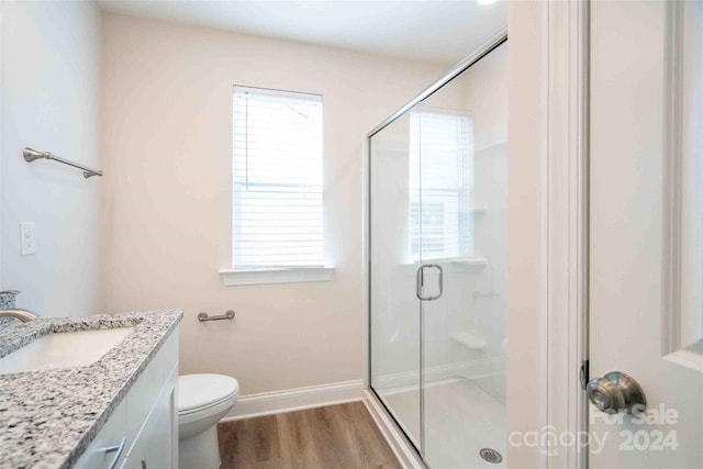 bathroom featuring hardwood / wood-style floors, toilet, an enclosed shower, and vanity