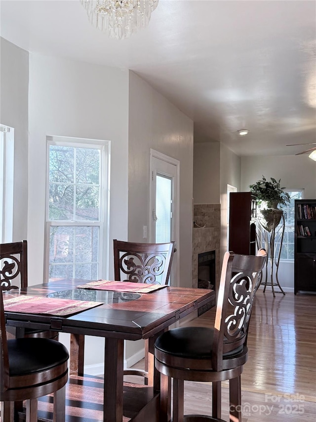 dining room with a fireplace, a chandelier, and hardwood / wood-style flooring