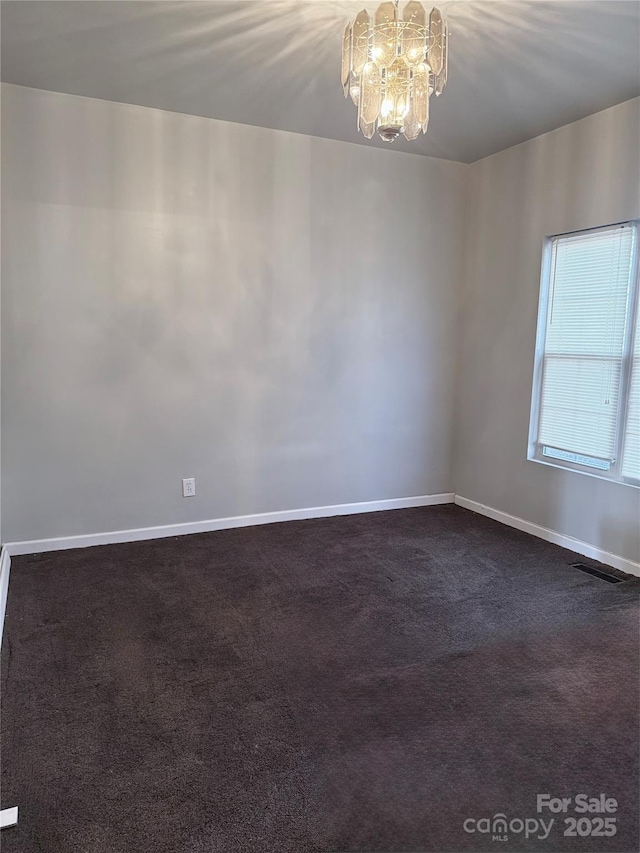 unfurnished room with carpet and an inviting chandelier