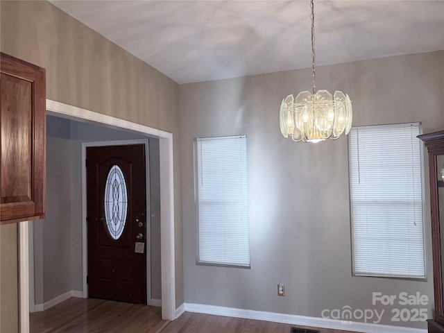 foyer entrance featuring hardwood / wood-style flooring and a chandelier