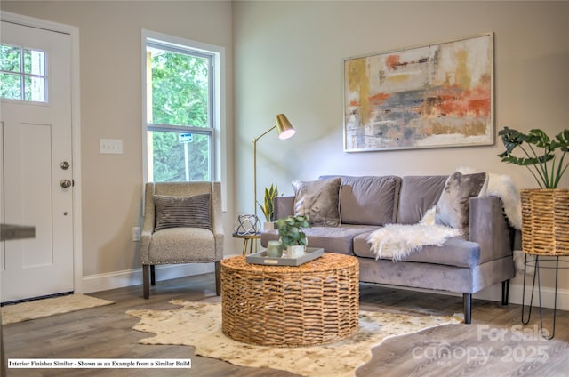 living area with plenty of natural light, wood finished floors, and baseboards