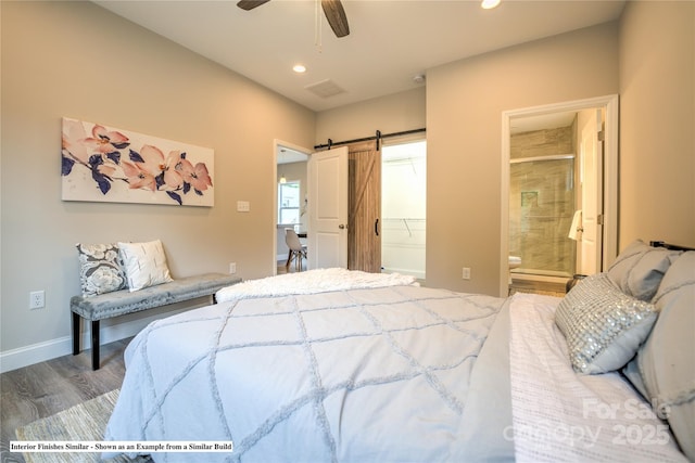 bedroom with ensuite bathroom, a barn door, recessed lighting, wood finished floors, and baseboards