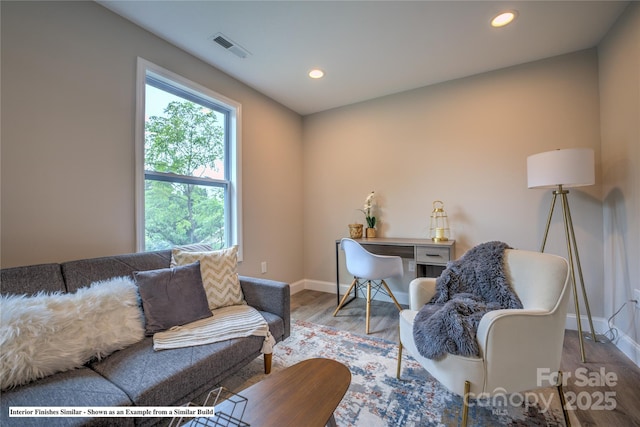 living area featuring baseboards, wood finished floors, visible vents, and recessed lighting