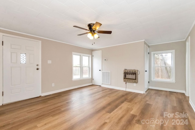 unfurnished living room with ceiling fan, crown molding, light hardwood / wood-style flooring, and heating unit