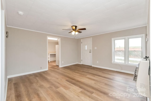 interior space with heating unit, light hardwood / wood-style flooring, ceiling fan, and crown molding