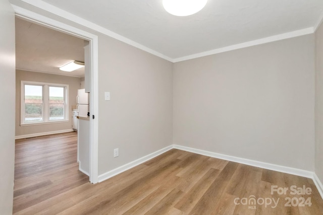 empty room featuring crown molding and light hardwood / wood-style flooring