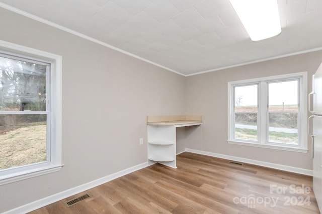 spare room featuring crown molding and light wood-type flooring