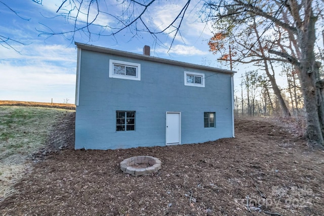 back of property with a fire pit