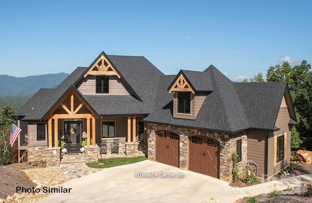 view of front of property featuring a mountain view, a garage, and covered porch