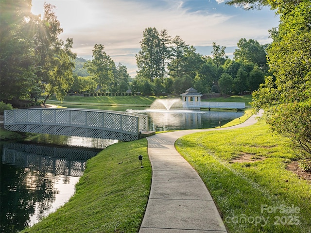 view of home's community with a water view and a yard